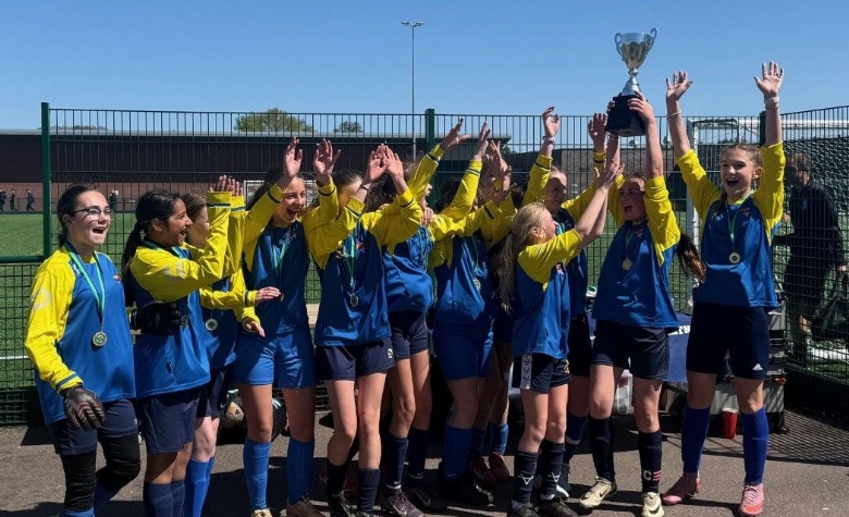 The Eckington School U12 Girls Football Team cheering and lifting their Derbyshire County Cup trophy